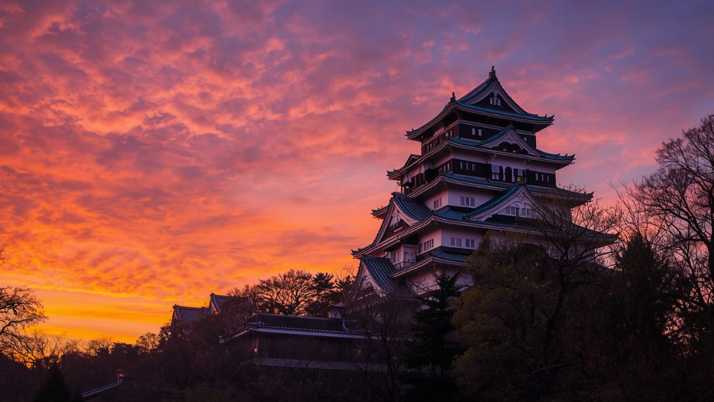 美しい夕焼け空に包まれ、老朽化の保全が望まれる歴史ある彦根城の天守閣
