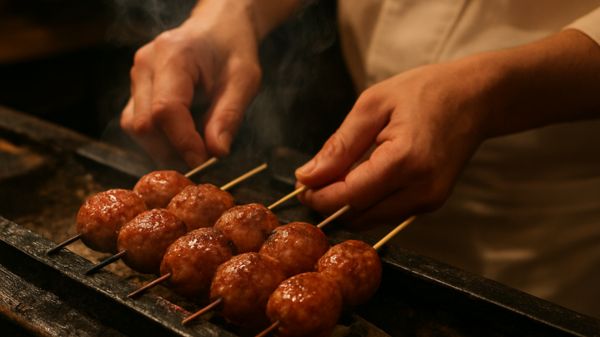 炭火で焼かれタレが絡んだ美味しそうなつくねの串焼き